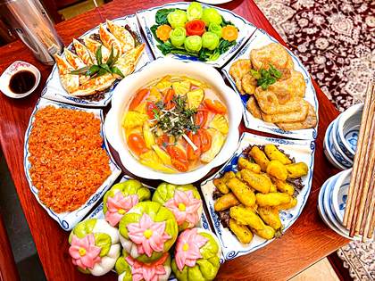Mâm cỗ chay đầy đủ với bánh sen, nem rán, đậu chiên, canh chua, xôi gấc và rau củ tỉa hoa